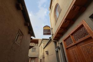 an alley with a sign on the side of a building at Jahangir Boutique Bukhara in Bukhara