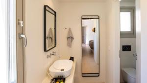 a bathroom with a sink and a mirror at Kalami Suites in Livadi