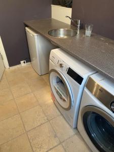 a washing machine in a kitchen with a sink at Central Copenhagen Apartment in Copenhagen