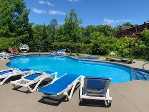 a swimming pool with two lounge chairs and a swimming pool at L'Authentique in Orford