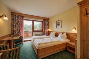 a hotel room with a bed and a window at Gasthaus Hotel Oberwirt in Ebbs