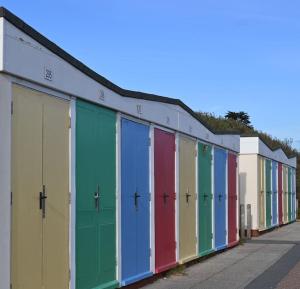 a row of brightly colored doors on a building at Apartment No. 8, 1 bed, sleeps 4 in Exmouth