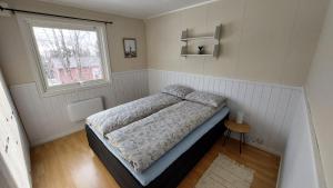 a bedroom with a bed and a window at Holiday home on Senja in Grashopen