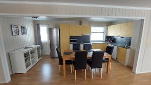 a kitchen with a table and chairs in a room at Holiday home on Senja in Grashopen