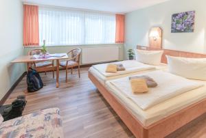 una camera d'albergo con due letti e un tavolo di Hotel Thüringenschanze a Oberhof