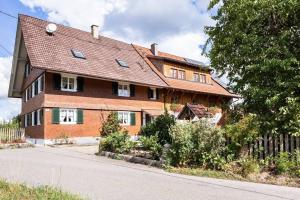 a large brick house with a gambrel roof at Naturidyl Schneckenbuch in Weißensberg