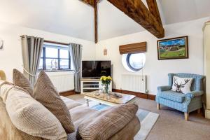 a living room with a couch and a table and a tv at The Saddlery Cheshire in Congleton