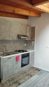 a kitchen with a sink and a stove top oven at Mansarda al mare in Pertegada