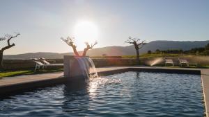 uma piscina com uma fonte de gua num quintal em Alto do Ferrum - Boutique Villa na Covilh