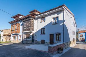 une maison blanche avec un toit marron dans l'établissement Apartamentos La Corrada de Andrín, à Andrín