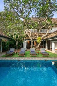 a swimming pool with lounge chairs and a house at Taru Villas Rampart Street - Galle Fort in Galle