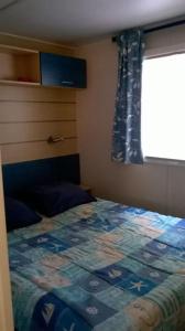 een slaapkamer met een bed met een quilt bij Mobilhome 6 personnes en bord de mer in Hyères
