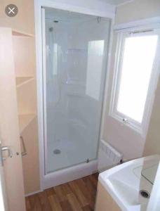 een witte badkamer met een douche en een wastafel bij Mobilhome 6 personnes en bord de mer in Hyères