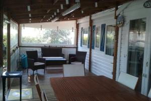 parawan na werandzie ze stołem i krzesłami w obiekcie Mobilhome 6 personnes en bord de mer w Hyères
