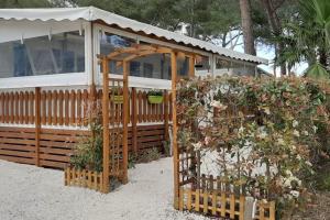 a wooden gazebo in front of a house at Mobilhome 6 personnes en bord de mer in Hyères