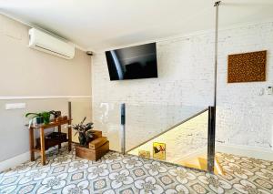 uma sala de estar com televisão numa parede de tijolos em BOOK DUPLEX REUS em Reus