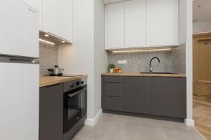 a kitchen with black and white cabinets and a sink at Business Apartments Kasprzaka by Noclegi Renters in Warsaw +66 photos