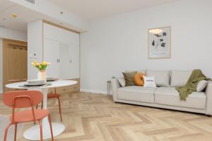 ワルシャワにあるBusiness Apartments Kasprzaka by Noclegi Rentersのソファとテーブルのあるリビングルーム