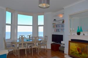 a dining room with a table and chairs and the ocean at Margate Seascape Retreat in Margate