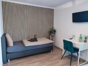 a room with a bed and a desk and a computer at Hotel Groote Engel in Emlichheim