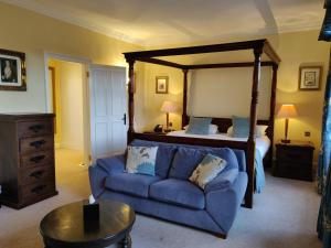 a living room with a bed and a blue couch at Dalhousie Castle Hotel in Bonnyrigg