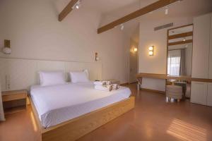 a bedroom with a bed with white sheets and a desk at June Alaçatı in Izmir