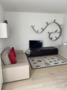 - un salon avec un canapé et une télévision dans l'établissement Maison Minù, à Porto Ceresio