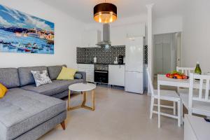 a living room with a couch and a table and a kitchen at Two bedroom apartment near the ocean in Playa de las Americas