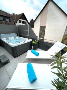 a patio with a jacuzzi tub on a balcony at WEiNECK Altenahr in Altenahr