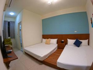 ein Schlafzimmer mit 2 Betten und einer blauen Wand in der Unterkunft Bear Baby Homestay in Jinning