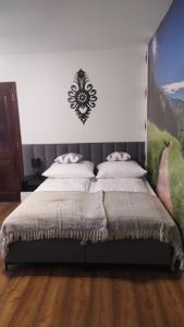 sypialnia z łóżkiem z obrazem na ścianie w obiekcie Czesławka w Zawoi