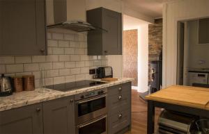 a kitchen with a stove top oven next to a table at Taobh na Mara in Kensaleyre