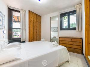 een slaapkamer met een groot wit bed en ramen bij Waterside Oasis House in Villasimius