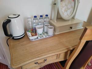 a table with a coffee maker and water bottles on it at Llety Teifi Guest House in Cardigan