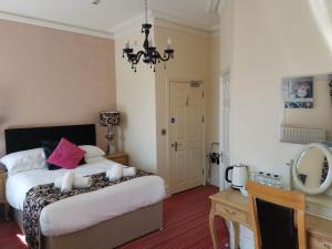 1 dormitorio con cama, mesa y espejo en Llety Teifi Guest House, en Cardigan