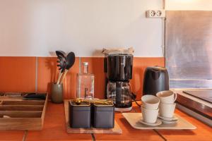 eine Küchentheke mit Kaffeemaschine und Tassen in der Unterkunft Pico do Refúgio - Casas de Campo in Ribeira Grande