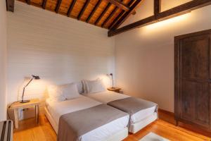 a bedroom with a large bed in a room at Pico do Refúgio - Casas de Campo in Ribeira Grande