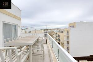 - Balcón con mesa y sillas en un edificio en Stylish 1BR Penthouse w Panoramic Views & BBQ by 360 Estates, en Il-Gżira