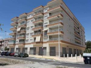 a large apartment building with cars parked in front of it at Apartamento Angel Salamanca 38 in Santa Pola