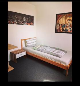 - un petit lit dans une chambre avec une photo sur le mur dans l'établissement Monteurwohnung nähe Bayreuth, Parken frei, Wifi, Küche, à Mistelgau