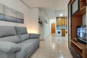 ein Wohnzimmer mit einem Sofa und einem Flachbild-TV in der Unterkunft Apartamento Maria Salamanca 8 in Santa Pola