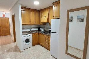 eine Küche mit einem weißen Kühlschrank und einer Waschmaschine in der Unterkunft Apartamento Maria Salamanca 8 in Santa Pola