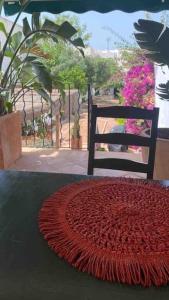 una alfombra roja en una mesa junto a una silla en Didi House - Charming in Downtown Mahon, en Mahón