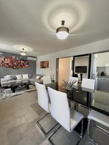 un soggiorno con tavolo e sedie bianche di DIEGO 4 pièces duplex a Nizza