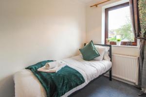 a small bedroom with a bed with a window at Comfortable 2 Bedroom House with Free Parking in Nottingham