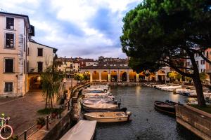 a group of boats docked on a river in a city at Flowers Apartments in Desenzano del Garda