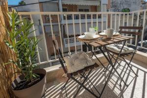 uma mesa e cadeiras numa varanda com plantas em 200Mbps brand-new studio in Athens em Atenas