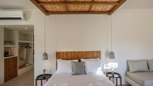 a bedroom with a bed and a couch at Kalami Suites in Livadi
