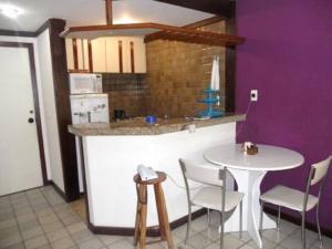 cocina con mesa, mesa blanca y sillas en Píer Sul Apart Hotel - Circuito do carnaval, en Salvador