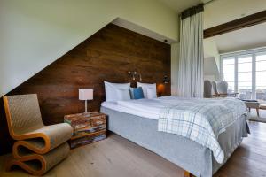 een slaapkamer met een groot bed en een houten muur bij Kontorhaus Keitum in Keitum